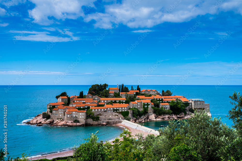 Montenegro, View above rocky sveti stefan isle with ancient stone houses with red roofs in summer vacation time