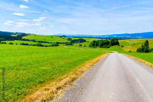 Cycling road around Tatra Mountains and green fields on summer day with beautiful blue sky, Poland