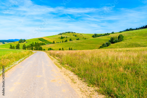 Cycling road around Tatra Mountains and green fields on summer day with beautiful blue sky, Poland