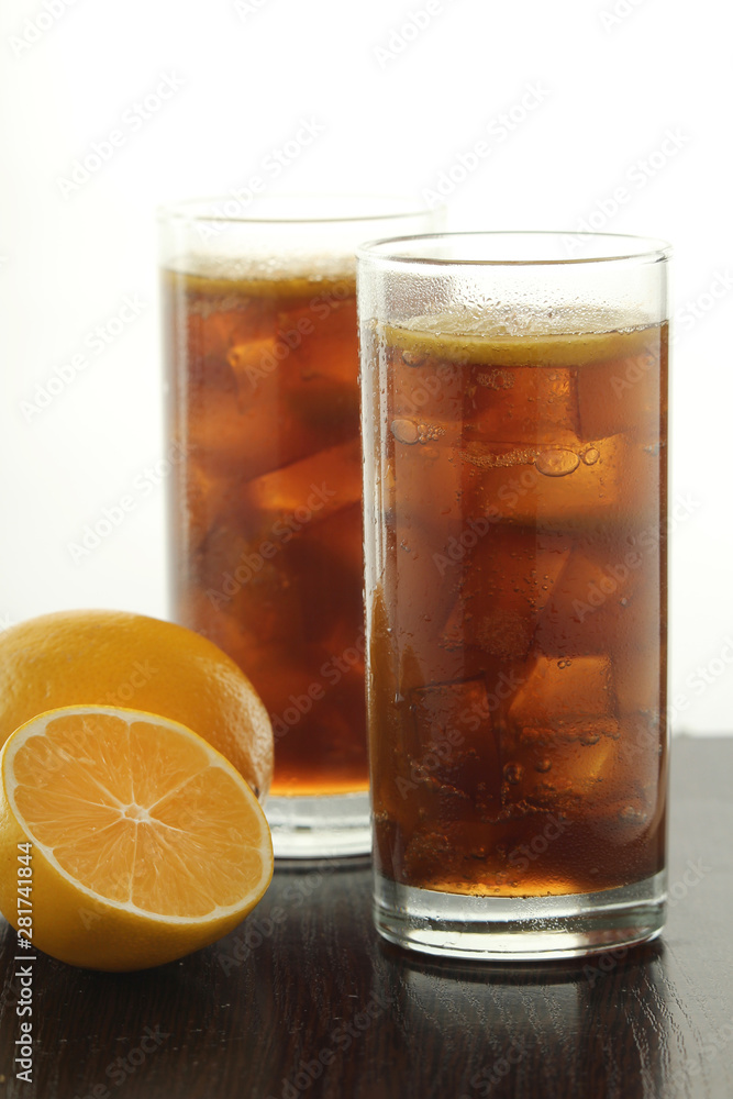 Glasses with cuba libre cocktail or cola with ice or cold tea with lemon Glasses with cuba libre cocktail or cola with ice or cold tea with lemon
