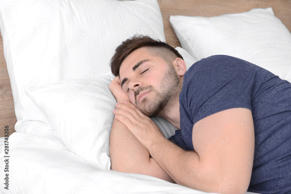 Handsome man sleeping in bed at home Handsome man sleeping in bed at home