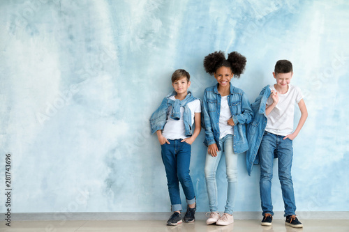 Stylish children in jeans clothes near color wall © Pixel-Shot