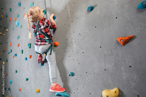 Little girl climbing wall i...