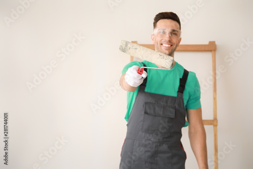 Male painter near light wall
