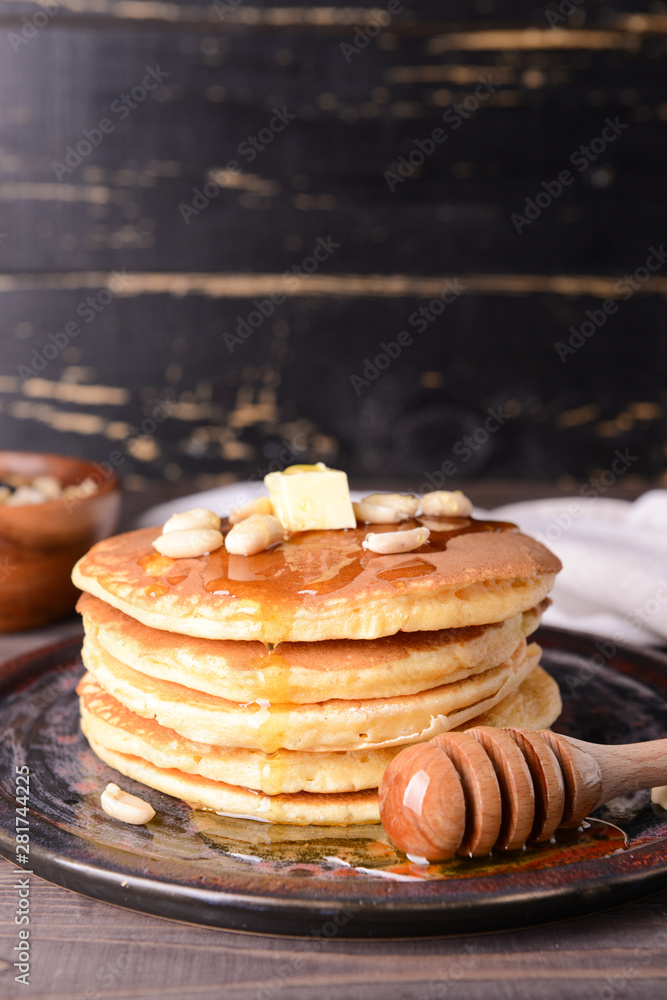 Tasty pancakes with honey and butter on table