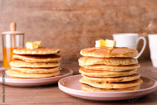 Tasty pancakes with butter on wooden table