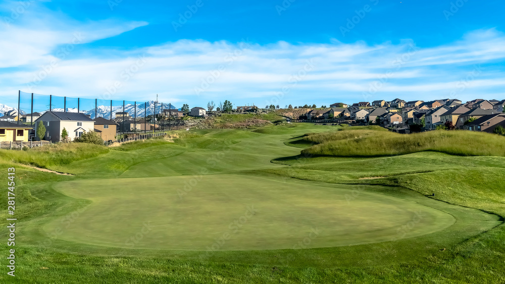 Panorama Golf course and homes under blue sky with clouds viewed on a sunny day