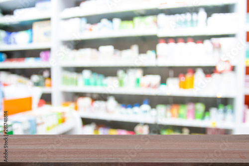 Wooden table top on blur images of medicines in pharmacies background - can be used for display or montague your products.Mock up for display of product. photo