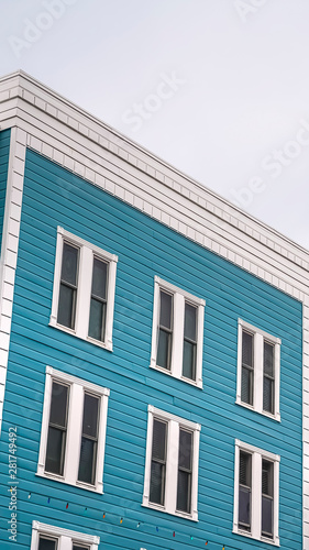 Vertical Residential building with blue exterior wall and vertical sliding windows