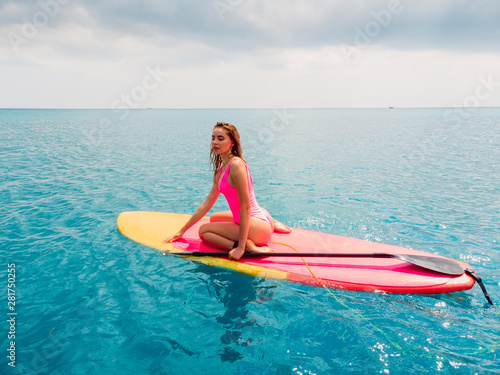 Aerial view of woman on stand up paddle board in ocean.