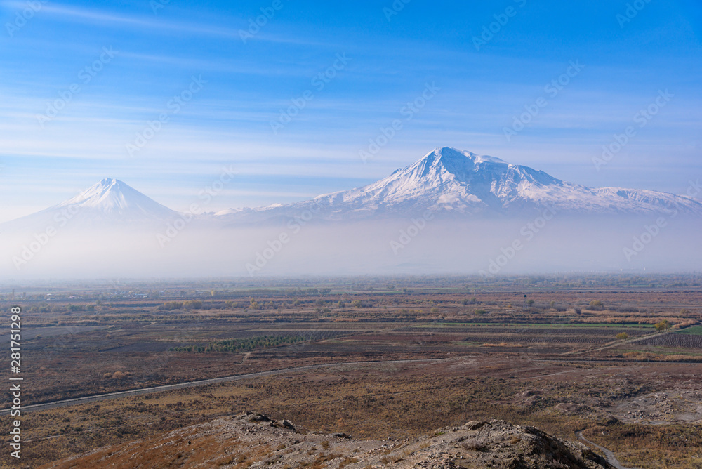 Mount Ararat is located on the Turkish territory with a view from the territory of Armenia from a high mountain near the Khor Virap monastery on a bright sunny day, with a hazy mist on the sky in the 