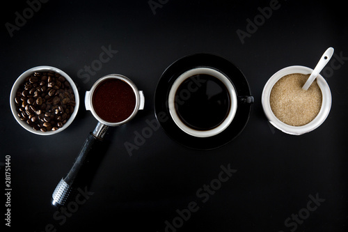 Coffee scene flat lay beans porta filter black coffee cup sugar arranged minimalist design