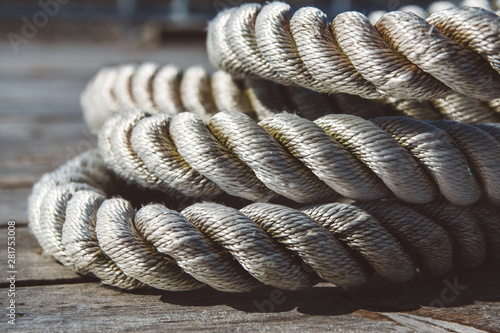 Close up of worn out thick mooring rope on wooden pier. Can use as banner