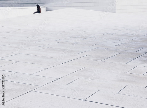 Photography woman sitting alone on Oslo opera house rooftop. Norway