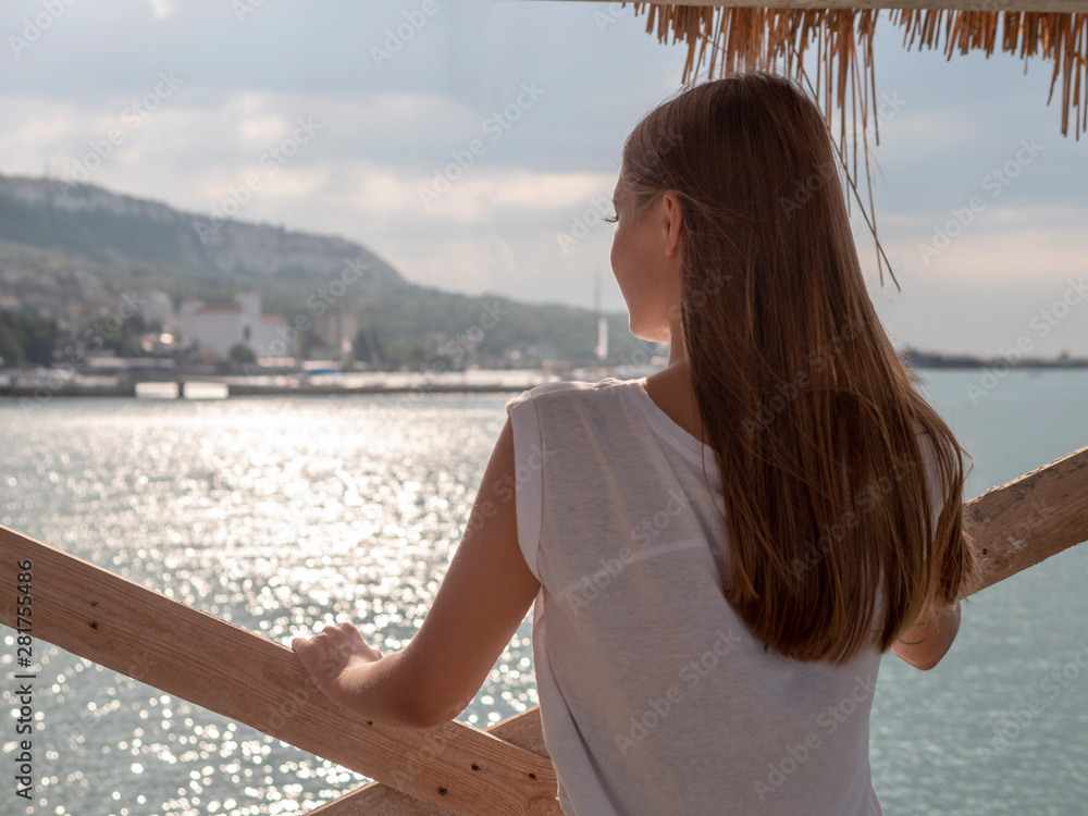 Sexy back of a beautiful unrecognizable woman looking at the sea with sun shine Sexy back of a beautiful unrecognizable woman looking at the sea with sun shine