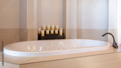 Slika na platnu Panorama frame Bathroom interior with close up view of a gleaming oval shaped bu