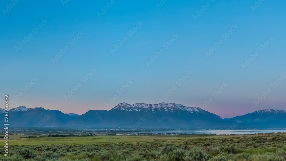 Panorama frame Scenic panoramic view of the valley lake and snow peaked mountain under blue sky Panorama frame Scenic panoramic view of the valley lake and snow peaked mountain under blue sky