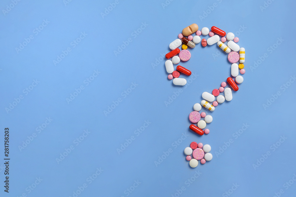 Question mark made of lots of pills and capsules on color background. Question mark made of lots of pills and capsules on color background.