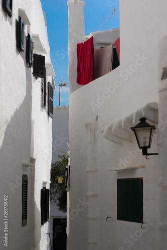 Narroe street with whitewashed facades in Binibeca, fishing village, Menorca, Spain photo