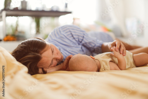 Caucasian Tender mother and baby are lying on bed