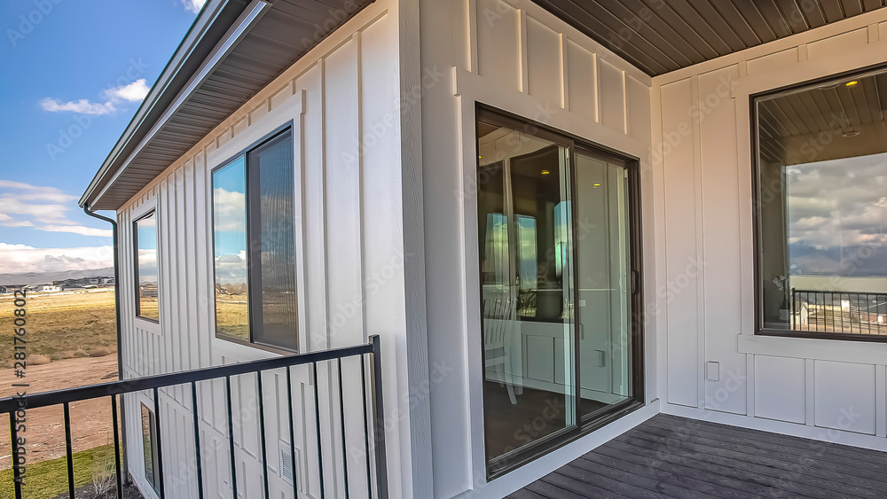 Fototapeta premium Panorama Home balcony with wooden floor metal railing and sliding glass access door