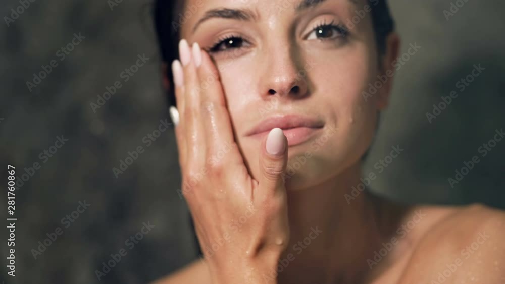 Close up portrait of young woman looking in the mirror after