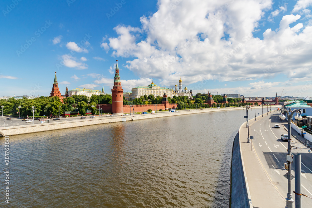 Obraz premium View of Moscow Kremlin and embankments of Moskva river in sunny summer morning against blue sky with white clouds