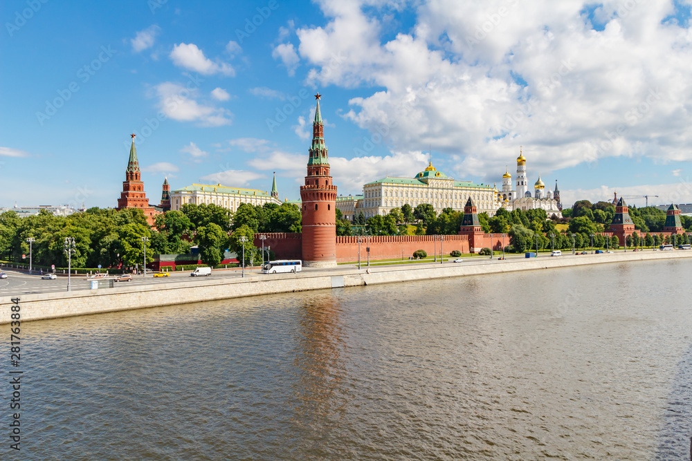 Moscow Kremlin and Moskva river at sunny summer morning against blue sky with white clouds