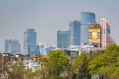 View of Moscow international business center Moscow-city against green trees and blue sky at sunny morning