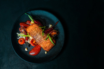 Delicious meal on a black plate, top view, copy space.