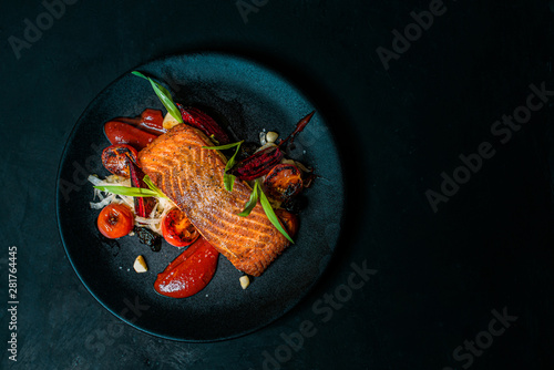 Delicious meal on a black plate, top view, copy space. photo
