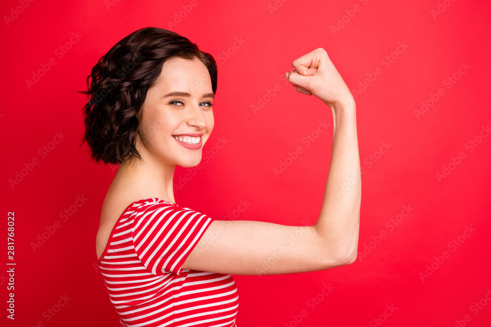 Photo of rejoicing wavy curly woman after having done two pushups while isolated with red background Photo of rejoicing wavy curly woman after having done two pushups while isolated with red background