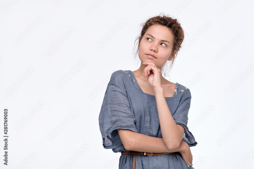 Beautiful young woman with dreadlocks in blue dress thinking looking up imaging her future plans. Isolated on white background