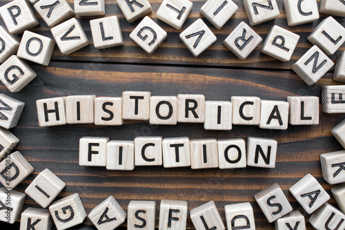 historical fiction - word from wooden blocks with letters, Literary Genres concept, random letters around, top view on wooden background photo