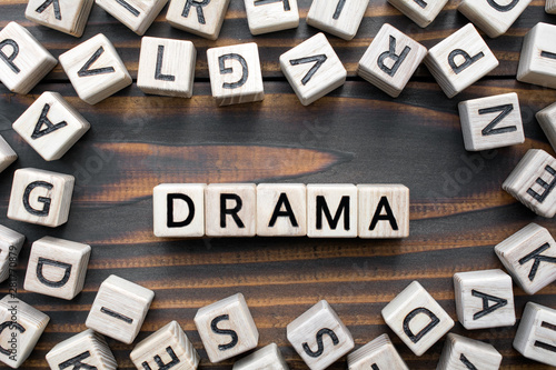 drama - word from wooden blocks with letters, Literary Genres concept, random letters around, top view on wooden background photo