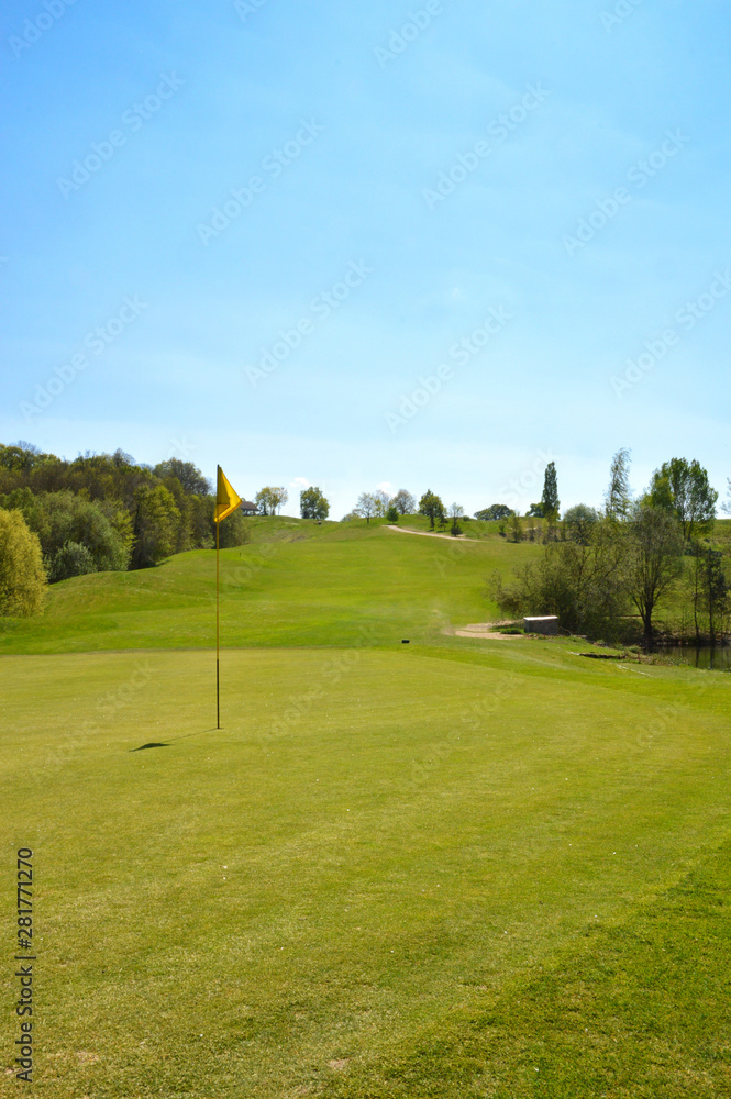 Putting green with golf flagstick on a golf course Putting green with golf flagstick on a golf course