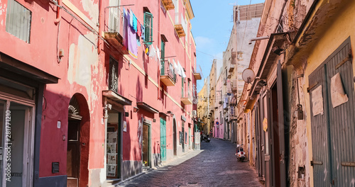 Fototapeta Naklejka Na Ścianę i Meble -  Daylight view on a colorful street of Procida island a sunny summer day. This italian island is famous for its vibrant pastel old houses and the Marina Corricella. Italy (Campania) – Image