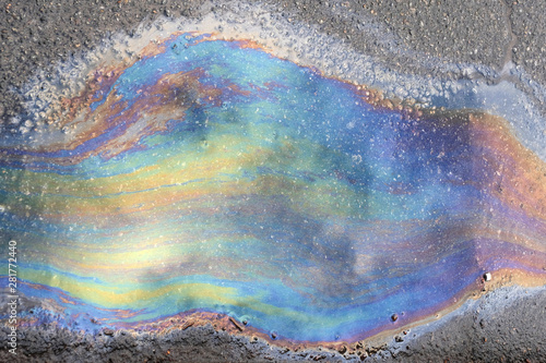 dirty multi-colored stain from engine oil on asphalt