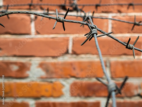 Brick fence and sharp barbed wire. No entry or exit