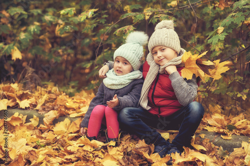 Children in warm clothes for a walk in the autumn Park
