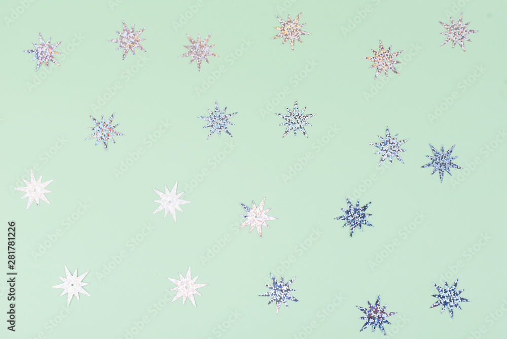 Festive and shiny background. Little stars on a light green background. Festive and shiny background. Little stars on a light green background.