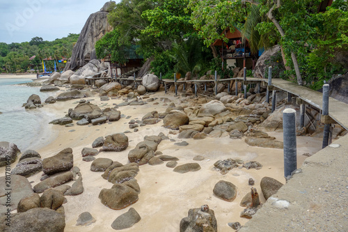 Very beautiful tropical beach with large stones on the island of Koh Samui. Wooden walkway along the beach. Thailand