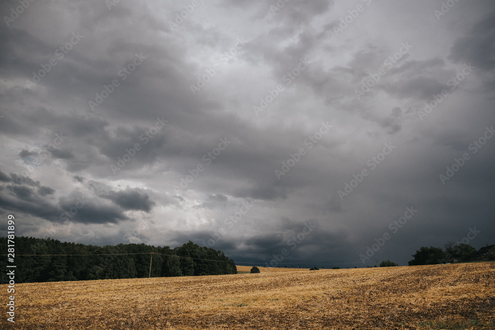 dramatic sky before thunderstorm over field in rural area dramatic sky before thunderstorm over field in rural area