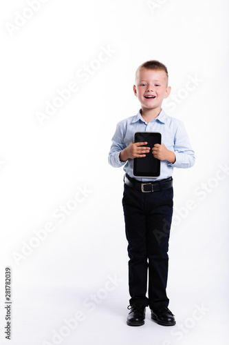 Happy little boy in suit hold tablet gadget. Children portrait. Back to school. Stylish man in fashionable suit shirt and pants with blue eyes