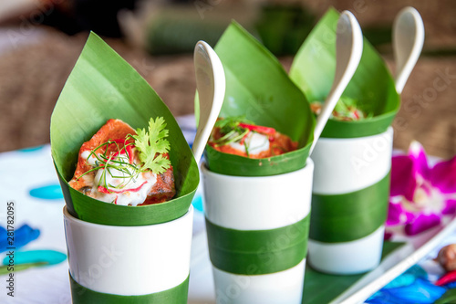 Hot curry decorated with banana leaves and purple flower put on a desk use for poster restaurant and web background.