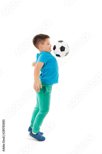Full length portrait of a child in sportswear jogging with a soccer ball. Isolated on white background