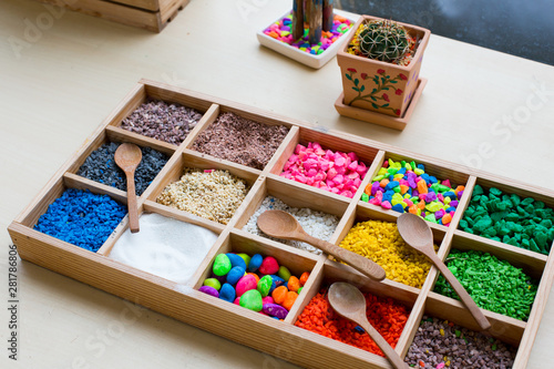 Colored pebbles mini stone and wooden spoons in wooden boxes for mini terrarium