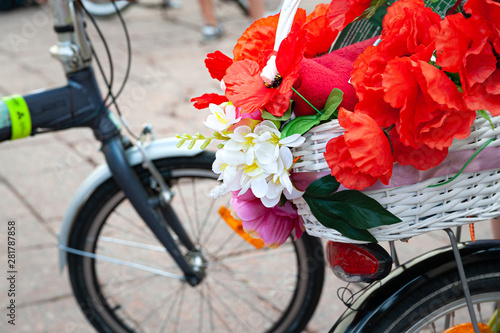 Kyiv, Ukraine - June 27, 2019: Girls' Bike Show-KYIV CYCLE CHIC. The annual women's bike parade. Close-up of a basket with red and white flowers on a bicycle.