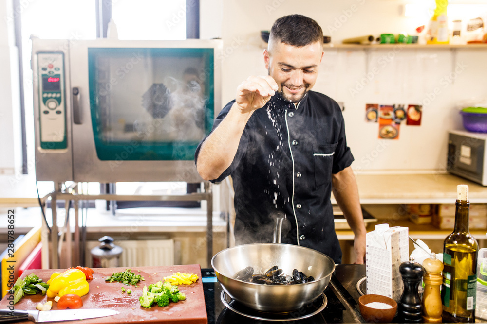 chef cooks mussels in a restaurant chef cooks mussels in a restaurant