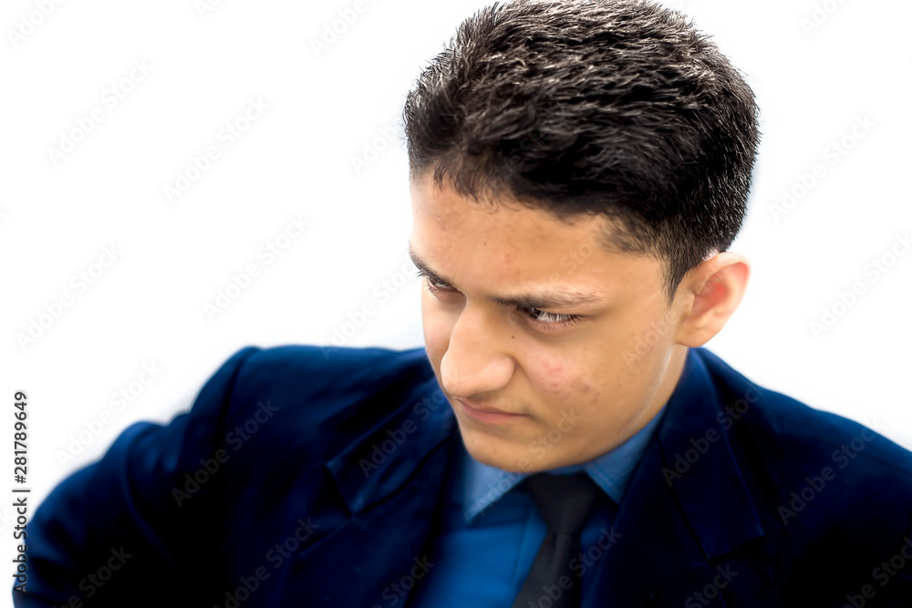 Portrait shot of a businessman wearing a blue colored suit with a black necktie and expressing anger on his face isolated on white in a mild manner. Portrait shot of a businessman wearing a blue colored suit with a black necktie and expressing anger on his face isolated on white in a mild manner.